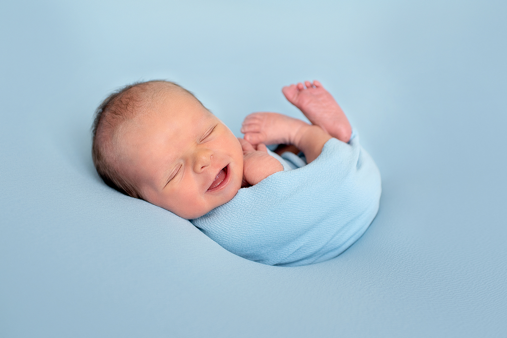 happy smiley sleeping newborn - professional newborn photography by Kelly McCambley
