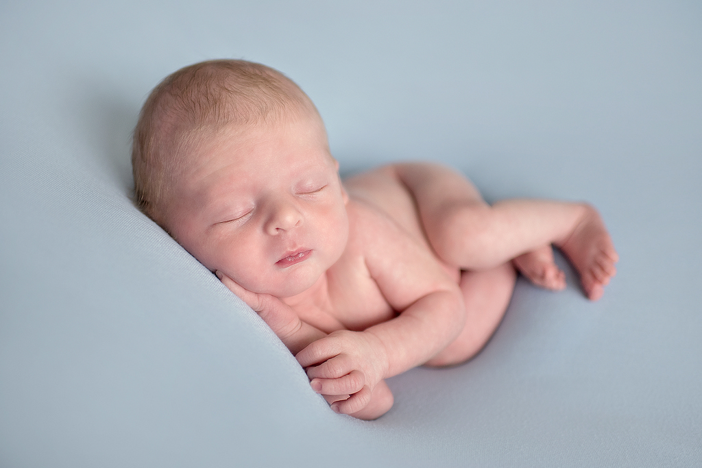 newborn baby stretched out asleep
